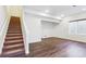 Finished basement with neutral walls, wood-look flooring, and a staircase at 2090 Candleglow St, Castle Rock, CO 80109