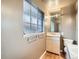 Clean bathroom with a pedestal sink, toilet, and a window at 5931 E 6Th E, Denver, CO 80220