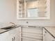 Small wet bar with sink, shelving and mirrored backsplash at 5931 E 6Th E, Denver, CO 80220