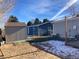 Spacious backyard with shed, artificial turf, and partial snow coverage at 1103 Stage Dr, Fort Lupton, CO 80621