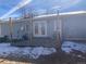 Cozy backyard with a wooden deck and partial snow coverage at 1103 Stage Dr, Fort Lupton, CO 80621