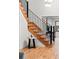 Modern staircase with wood steps and black metal railing at 1 Winged Foot Way, Littleton, CO 80123