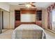 Bedroom with built-in headboard, shelving, drawers, and mirrored closet doors at 585 S Alton Way # 4D, Denver, CO 80247