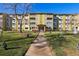 Front exterior of the apartment building with holiday decorations, walkway, and landscaped lawn at 585 S Alton Way # 4D, Denver, CO 80247