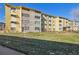 Exterior view of the apartment building from the back, showcasing the lawn and landscaping at 585 S Alton Way # 4D, Denver, CO 80247