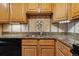 Kitchen features granite countertops, oak cabinets, and decorative tile backsplash at 585 S Alton Way # 4D, Denver, CO 80247