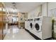 Shared laundry room with multiple washers and dryers, folding counter, and laundry guide at 585 S Alton Way # 4D, Denver, CO 80247