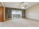 Living room with sliding glass door to balcony, ceiling fan, and carpeted floors at 585 S Alton Way # 4D, Denver, CO 80247