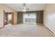 Carpeted living room with ceiling fan, sliding glass door to balcony, and bedroom access at 585 S Alton Way # 4D, Denver, CO 80247