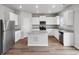 Modern kitchen with white cabinets, granite countertops, and stainless steel appliances at 2204 Alyssa St, Fort Lupton, CO 80621