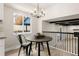 Bright dining area with a round table, black chairs, and a modern chandelier at 5535 W Indore Dr, Littleton, CO 80128