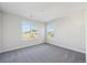 Well-lit bedroom featuring grey carpet and multiple windows at 1050 Joseph Pl, Erie, CO 80026