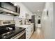 Modern kitchen with white cabinets, herringbone tile backsplash, and stainless steel appliances at 336 N Grant St # 206, Denver, CO 80203
