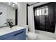 Bathroom with blue vanity, black tile shower, and white toilet at 336 N Grant St # 206, Denver, CO 80203