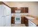 View of kitchen with wood cabinets and white appliances at 9612 W Chatfield Ave # C, Littleton, CO 80128