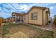 Tan house exterior with a covered patio and a well-maintained yard at 9804 Truckee St, Commerce City, CO 80022