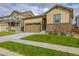 Tan single-story house with a two-car garage and manicured lawn at 9804 Truckee St, Commerce City, CO 80022