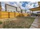 Large backyard with a wooden fence and stone pathway at 9804 Truckee St, Commerce City, CO 80022