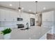 White kitchen cabinets, quartz countertops, and herringbone backsplash at 954 Plum Creek Ct, Brighton, CO 80601