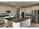 Modern kitchen featuring white cabinets, stainless steel appliances, and a large island with dark countertops at 1090 Sunrise Dr, Erie, CO 80516