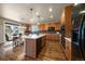 Open kitchen with wood cabinetry, stainless steel appliances, an island with seating, and a dining area at 10967 Bellbrook Cir, Highlands Ranch, CO 80130