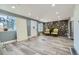 Bright living room with stone accent wall and wood floors at 7321 Carnation Pl, Commerce City, CO 80022