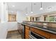 Basement wet bar with granite countertop, stainless steel appliances, and tile flooring at 1199 Links Ct, Erie, CO 80516