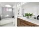 Bathroom with gray tile, marble vanity, and bathtub at 1339 E 131St Dr, Thornton, CO 80241