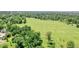 Aerial view showing a large grassy field with mature trees and distant cityscape at 730 E Alameda Ave, Denver, CO 80209