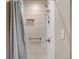 Clean shower with a shower curtain and grab bars for accessibility at 3278 S Oneida Way, Denver, CO 80224