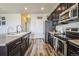 Modern kitchen with dark cabinets, stainless steel appliances and hardwood floor at 13644 Ulster St, Thornton, CO 80602