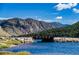 Bridge over calm lake water with mountain backdrop at 2121 Hummingbird Way # 203, Georgetown, CO 80444
