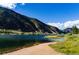 Calm lake with sandy shore and mountain backdrop at 2121 Hummingbird Way # 203, Georgetown, CO 80444