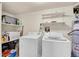 Well-lit laundry room with washer, dryer, and storage shelves at 17662 E Loyola Dr # 2132L, Aurora, CO 80013