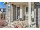 Townhome front entrance with stone accents, a covered porch, and potted plants at 17207 E Exposition Dr, Aurora, CO 80017