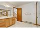 Bright bathroom with wood cabinets and a view to the staircase at 33804 Bergen View Trl, Evergreen, CO 80439