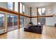 Living room with hardwood floors, a leather couch, and large windows showcasing a mountain vista at 33804 Bergen View Trl, Evergreen, CO 80439