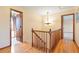 Upstairs hallway with wood railing and chandelier at 11102 Zephyr St, Westminster, CO 80021