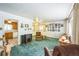 Spacious living room with green carpet and view of kitchen at 1646 S Winona Ct, Denver, CO 80219