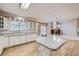 Kitchen with white cabinets, granite countertops and island, open to the living room at 8336 Vivian St, Arvada, CO 80005