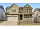 Two-story house with gray siding, stone accents, and a two-car garage at 574 Twilight St, Erie, CO 80516