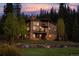 Multi-level home with stone and wood exterior, decks, and hot tub at sunset at 1920 Tiger Rd, Breckenridge, CO 80424