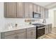 Modern kitchen with gray cabinets, white quartz countertops, and stainless steel appliances at 992 Magnolia St, Erie, CO 80516