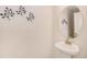 Simple bathroom with pedestal sink, oval mirror, and wall sconces at 992 Magnolia St, Erie, CO 80516