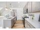 Modern kitchen with gray cabinets, stainless steel appliances, and a large island at 992 Magnolia St, Erie, CO 80516