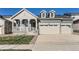 Two-story house with grey siding, beige garage, and landscaped lawn at 1255 Sunrise Dr, Erie, CO 80516