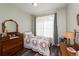 Charming bedroom with antique furniture and large window with curtains at 12711 Colorado Blvd # 912, Thornton, CO 80241