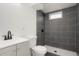 Basement bathroom with grey tile shower and vanity at 7956 Joan Dr, Denver, CO 80221