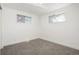 Bright basement bedroom with grey carpet and two windows at 7956 Joan Dr, Denver, CO 80221