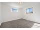 Bright bedroom with neutral walls, carpet flooring, and two large windows at 7956 Joan Dr, Denver, CO 80221
